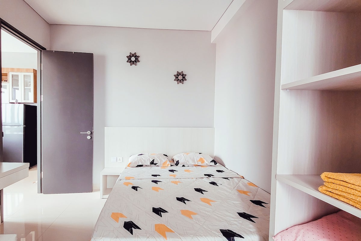 Ein modernes Schlafzimmer mit Bett, Schreibtisch und Kleiderschrank.