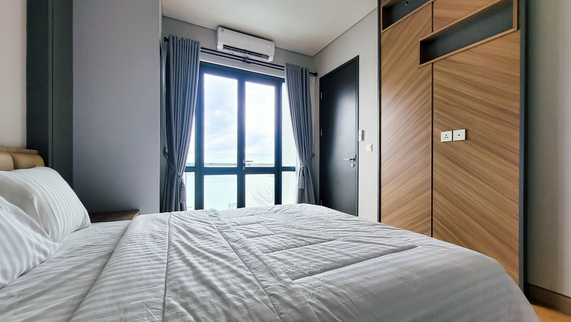 Una camera da letto moderna con un letto grande, un armadio e vista da una finestra.