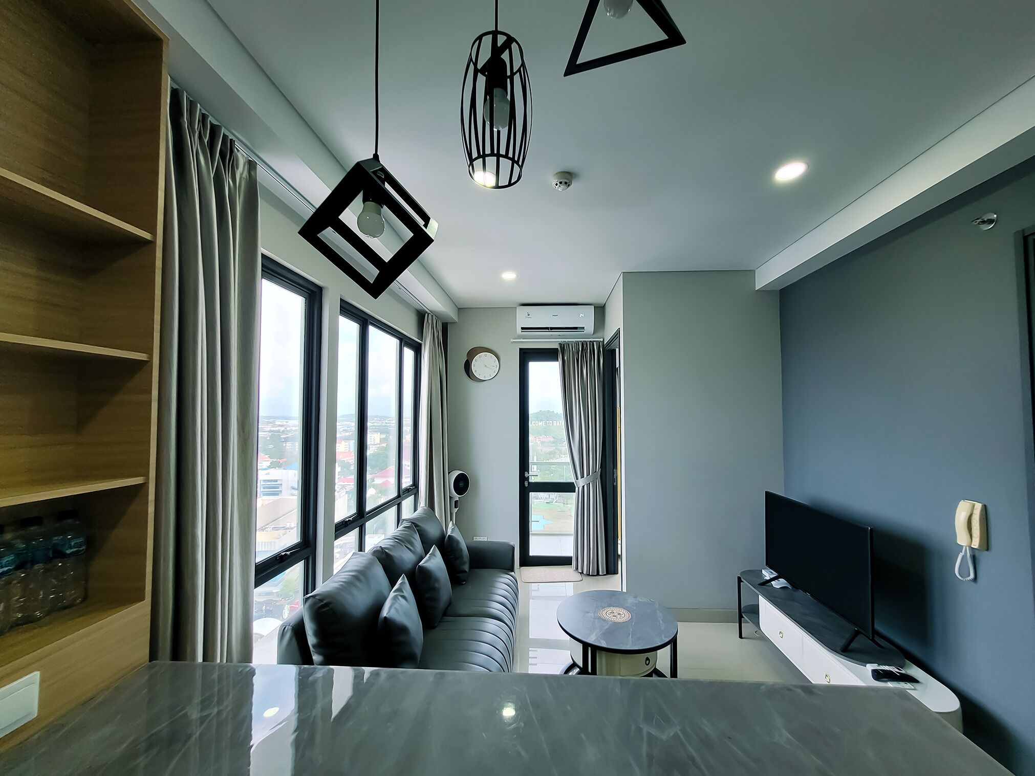 Una sala de estar moderna con un sofá, un televisor y una mesa de comedor.