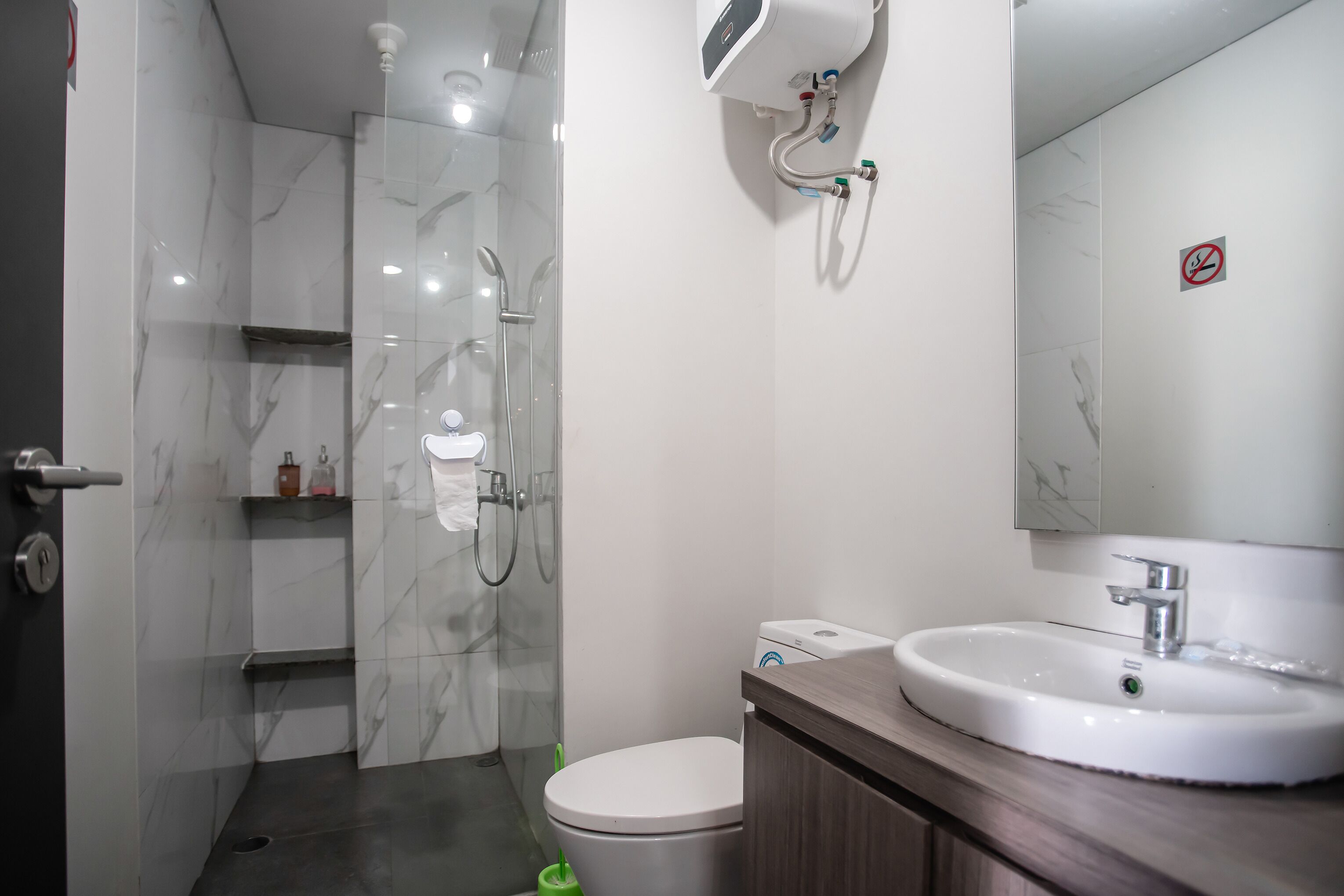 A modern bathroom with a glass shower enclosure, a white toilet, and a vanity with a sink.