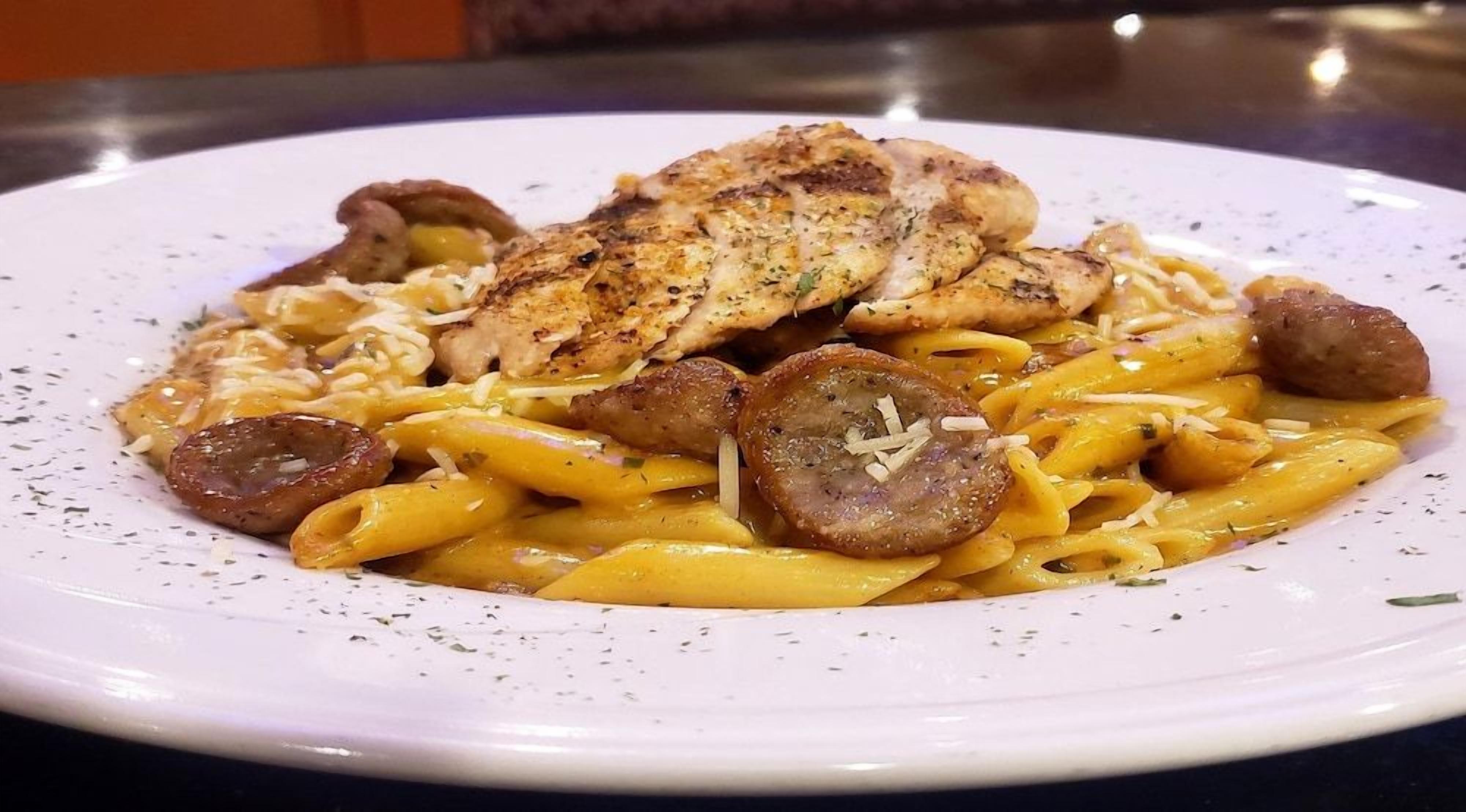 A plate of pasta with chicken and mushrooms.