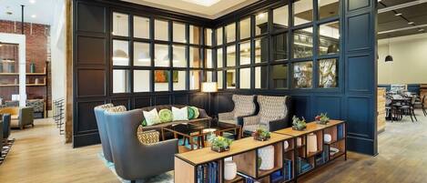 A modern living room with a sectional sofa, a coffee table, and a bookshelf.