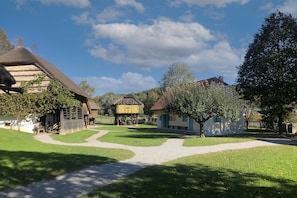 A rural village with traditional buildings, a thatched-roof structure, and a clear sky. - Farmhouse at St. Donat's (Rogatec)