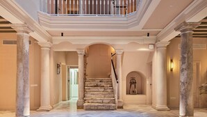 A grand staircase with marble steps, flanked by columns, leading to a balcony with a white balustrade. - Villa de Andas (Cádiz)