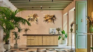 A reception area with a check-in counter, a patterned floor, and several potted plants. - Villa de Andas (Cádiz)