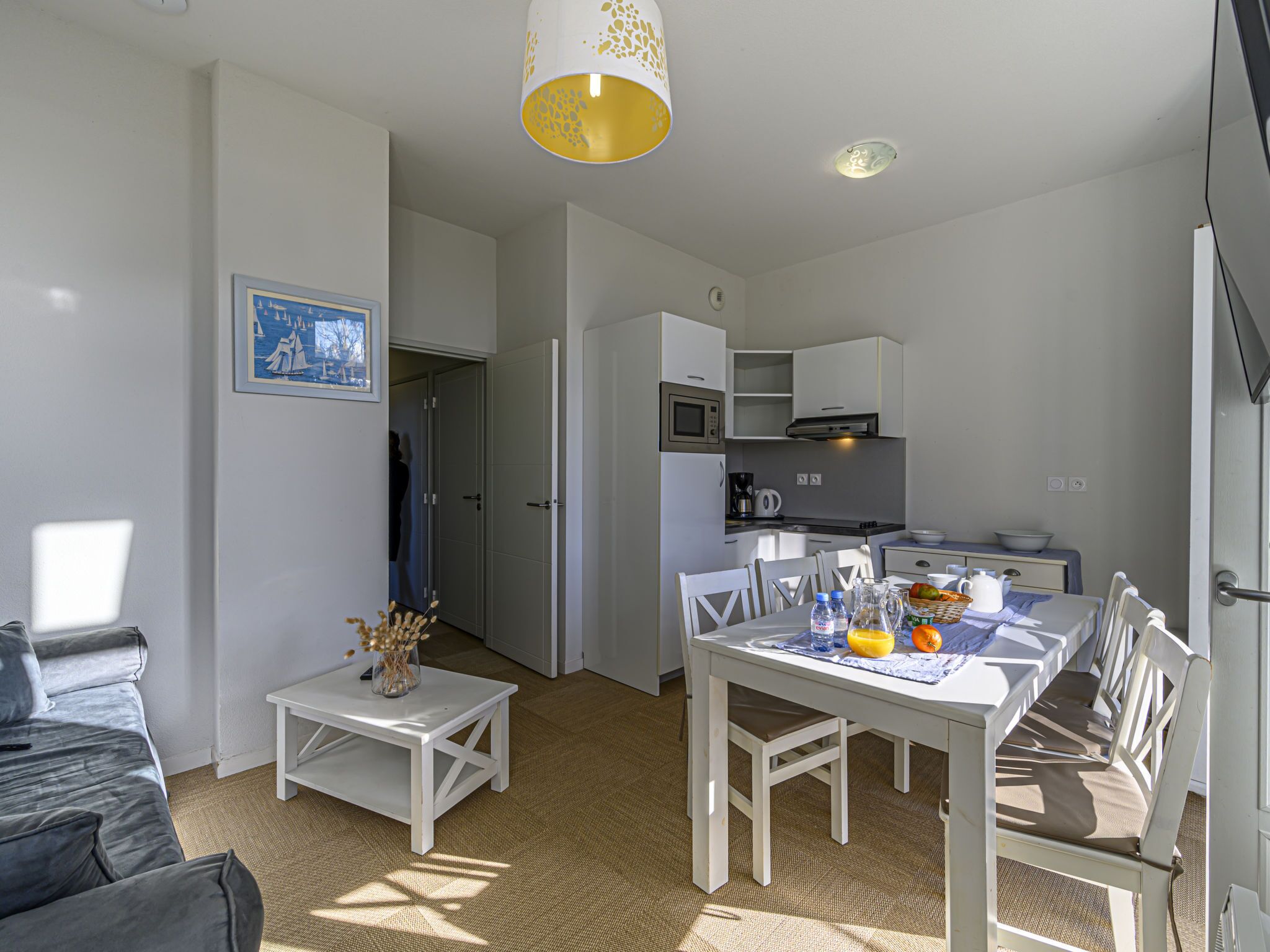 A compact living space with a dining area, kitchenette, and a bed.