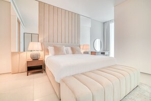 Een moderne slaapkamer met een groot bed, nachtkastjes, een spiegel en een raam.