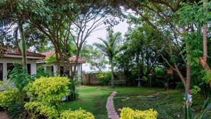 Un jardín con un sendero que lleva a un edificio de techo a tejas.