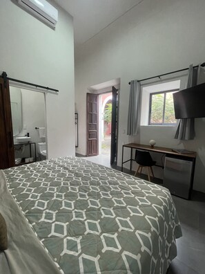 A bedroom with a bed, a desk, a chair, a TV, and a window. - Quinta la Perla (Guadalajara)