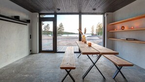 A modern interior with a wooden ceiling, large windows, and a view of a lake. - Saunamäki Resort Guesthouse - Countryside Views (Salo)