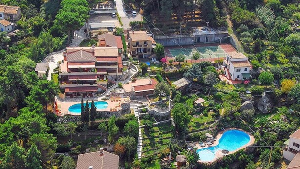 A residential area with multiple buildings, a tennis court, and two swimming pools surrounded by lush greenery. - RTA Capo Sant'Andrea - Capo Sant'Andrea - Trilo 5 nr° 1 (Marciana)
