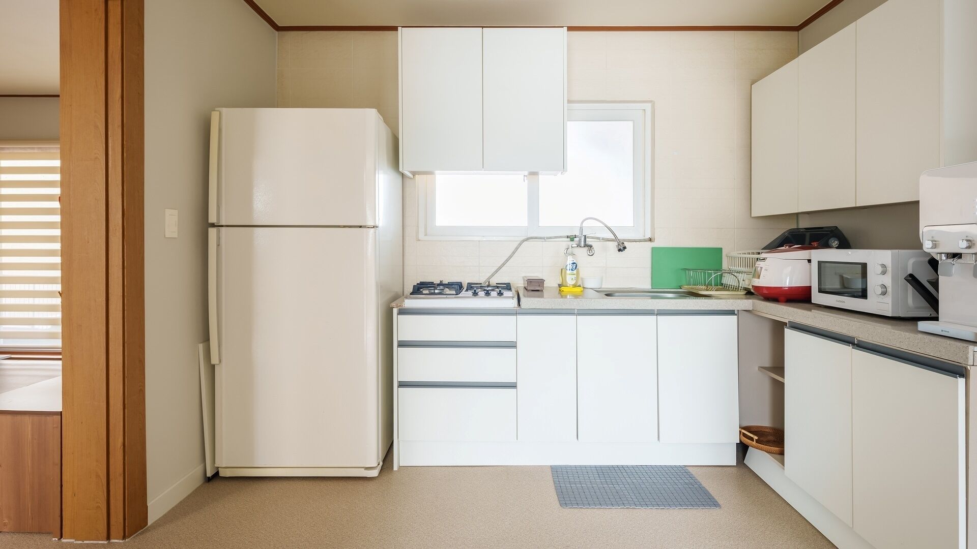 Una cocina compacta equipada con refrigerador, estufa, microondas y gabinetes.
