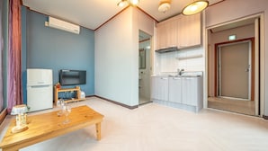 A modern apartment with a living area, kitchen, and a door leading to a bathroom. - Daebudo Green Beach Pension (Ansan)