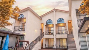 Un edificio de varios pisos con balcones, escaleras y zonas de estar al aire libre.