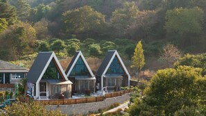 A row of modern, triangular-roofed cabins with large windows, set against a backdrop of dense forest. - Gapyeong The Paran Private Pool Villa (Gapyeong)
