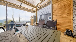 A wooden deck with a table, chairs, a lantern, and a grill. - Gapyeong The Paran Private Pool Villa (Gapyeong)