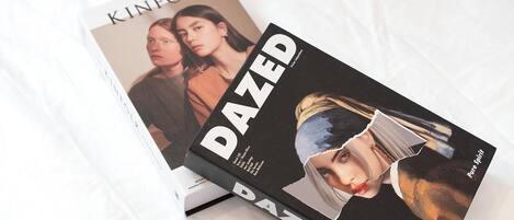 Two books titled 'KINFOLK' and 'DAZED' on a white surface.