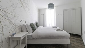 A modern bedroom with a bed, bedside table, lamp, and a wardrobe. - Italianway Comfort - Buenos Aires 65 E (Milan)