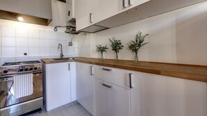 Une cuisine moderne avec des armoires blanches, un plan de travail en bois et une cuisinière en acier inoxydable.