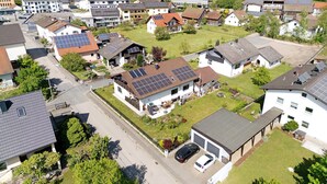 Een woonwijk met huizen voorzien van zonnepanelen, een straat en een verre brug.