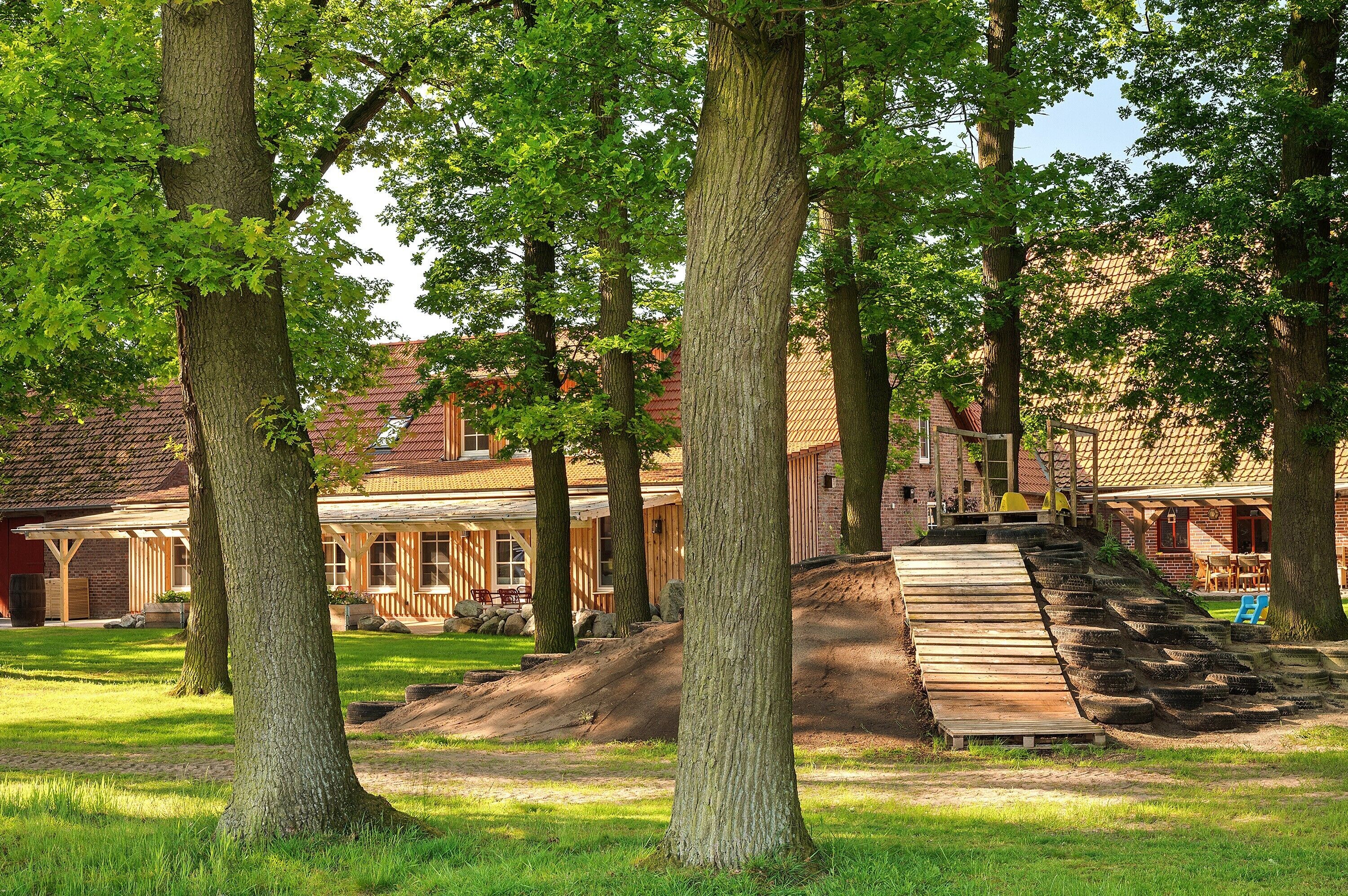 A rustic building with a wooden deck and a ramp leading to a porch.