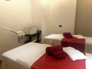 Two single beds with red and white linens, a mirror, a small table with a hairdryer, and a towel rack. - Welcomhotel By ITC Hotels Belagavi (Belagavi)