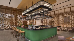 A modern bar area with a green counter, bar stools, and a variety of bottles and glasses. - Welcomhotel By ITC Hotels Belagavi (Belagavi)