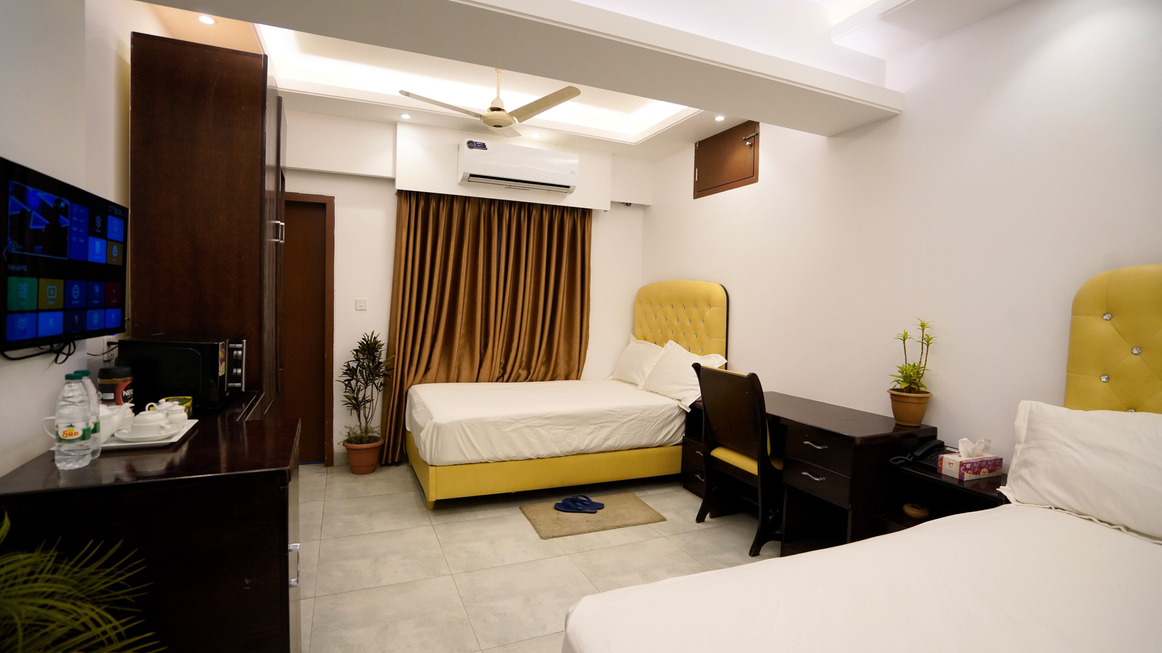 Una habitación de hotel con cama, escritorio, silla y televisor.