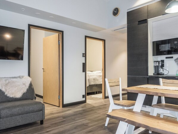 Une chambre moderne comprenant un canapé, une table à manger avec des chaises, un lit et un coin cuisine.