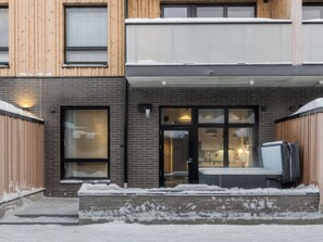 Un bâtiment à deux étages, doté d’une façade en briques, d’un revêtement extérieur en bois et d’une entrée en verre.