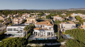 Un quartier résidentiel où les maisons présentent une architecture méditerranéenne, avec piscine et panneaux solaires.