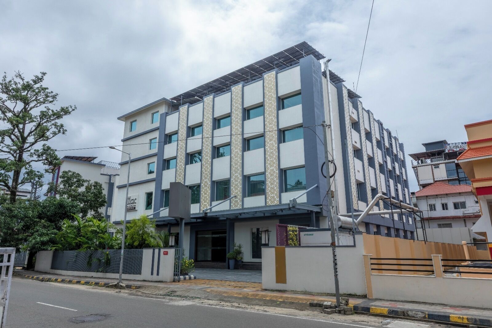 A multi-story hotel with a modern facade, large windows, and a gated entrance.