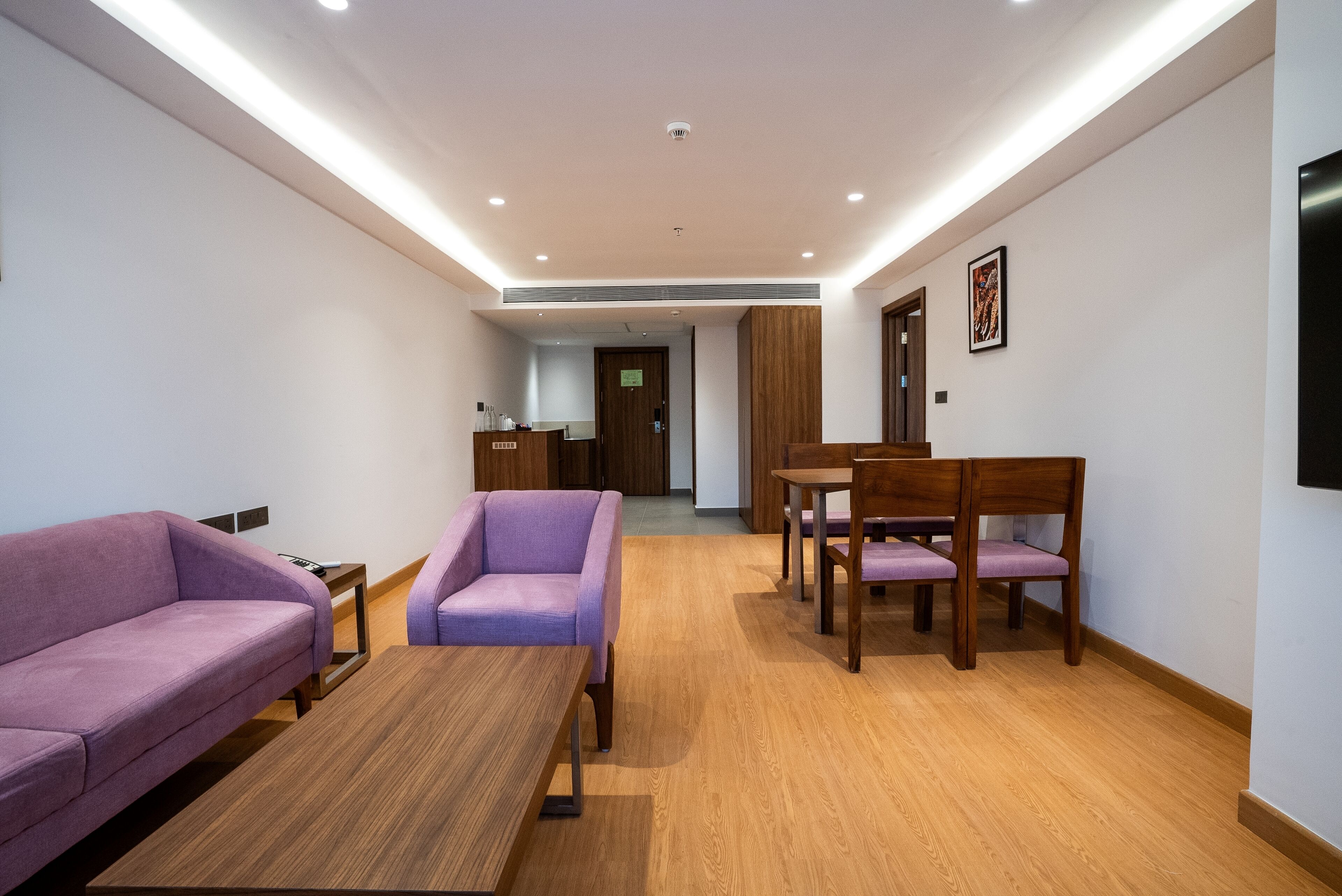A modern living room with a sofa, armchair, and wooden coffee table.