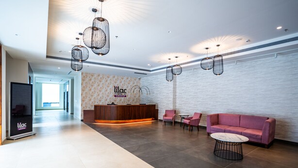 A modern hotel lobby with a reception desk, seating area, and a reception counter. - Rae by Tamara Guruvayur - Formerly Lilac Guruvayur (Chavakkad)
