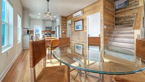 Una cocina moderna con armarios blancos, electrodomésticos de acero inoxidable y una pared de acento de madera.
