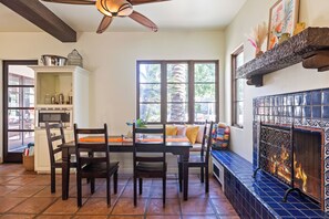Un espace repas comprenant une table et des chaises, une cheminée et une vue sur l’extérieur.