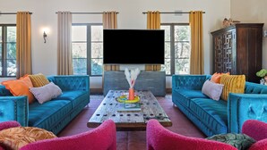 Un salon avec un canapé bleu, une table basse et un téléviseur.