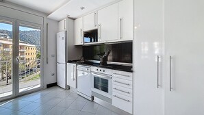 Una cocina moderna con armarios blancos, estufa, horno y microondas.