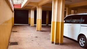 A covered parking area with columns and a white car parked on the right.