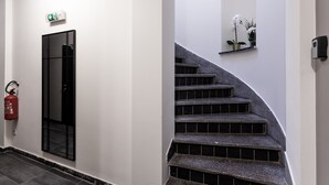 Un escalier muni d’une rampe et d’un extincteur fixé au mur.