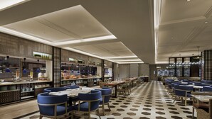 A modern restaurant with a long counter, blue upholstered chairs, and a patterned floor. - PARKROYAL A'Famosa Melaka Resort (Alor Gajah)