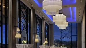 A spacious room with large windows, multiple chandeliers, and tables set up for events. - PARKROYAL A'Famosa Melaka Resort (Alor Gajah)