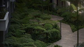 A pathway through a lush garden with ferns and palm trees. - PARKROYAL A'Famosa Melaka Resort (Alor Gajah)