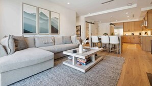 A modern living room with a sofa, coffee table, and artwork on the wall.