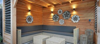 The holiday home is located on a dead-end street in the beautiful, peaceful, and wooded park Jonkerstee with a spacious canopy featuring a lounge sofa.