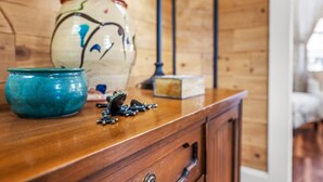 Ein Holzschrank mit einer Keramikfroschfigur, einer blauen Schüssel und einem dekorativen Glas