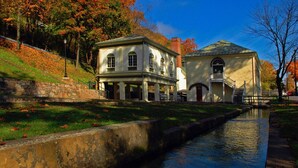 Ein historisches Gebäude mit überdachter Galerie und einem Kanal davor.