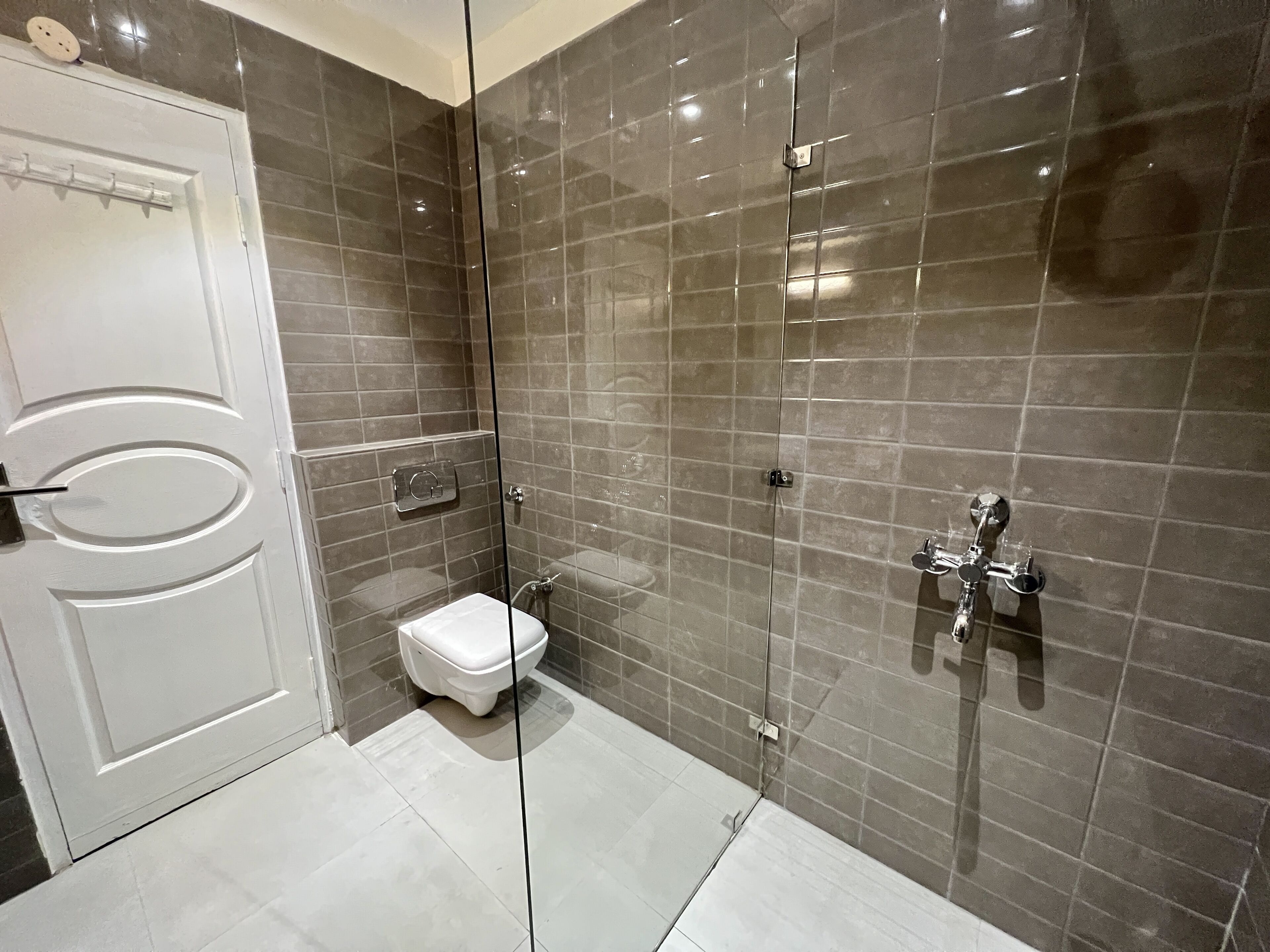 Un baño moderno con ducha de vidrio, inodoro blanco y lavamanos empotrado.