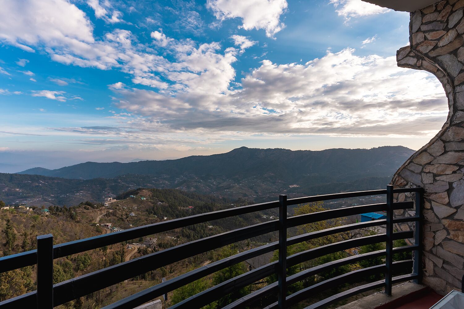A stone balustrade overlooking a mountainous landscape with a clear sky.