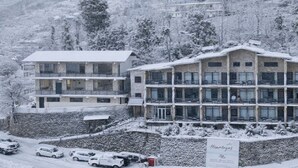 Een hotel met meerdere verdiepingen, een gevel van steen, diverse balkons en een bord dat een restaurant aangeeft.
